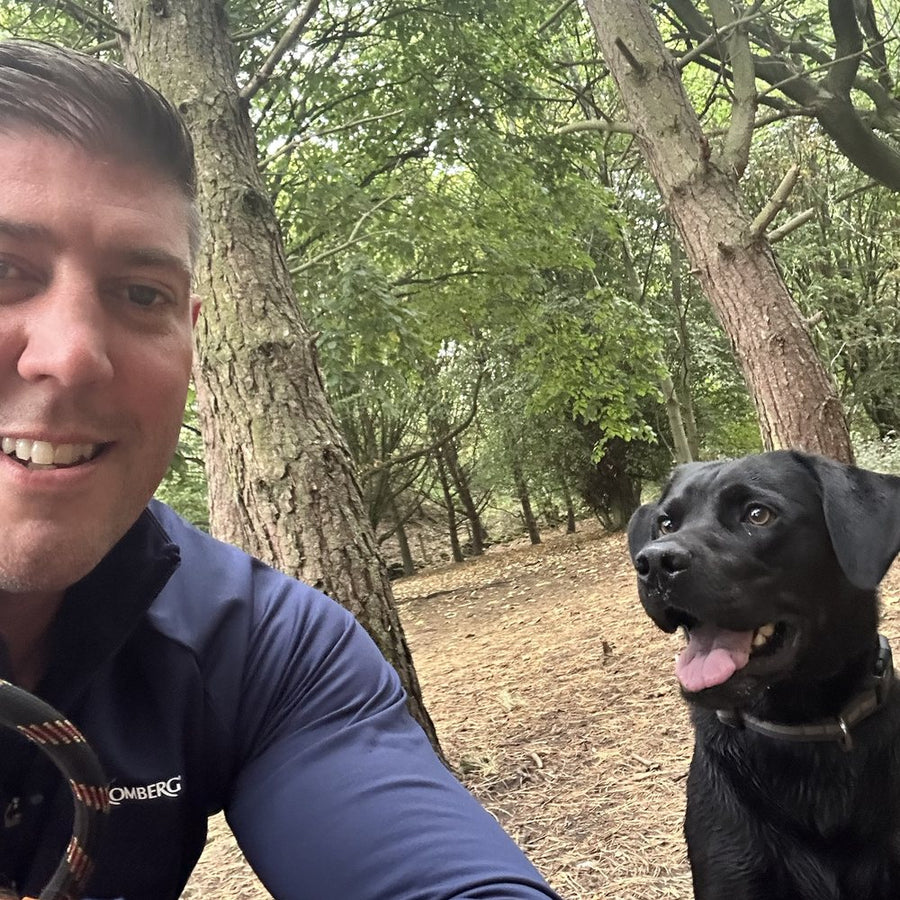 Petchup founder Adam Corcoran with his black Labrador Ozzy on a woodland walk